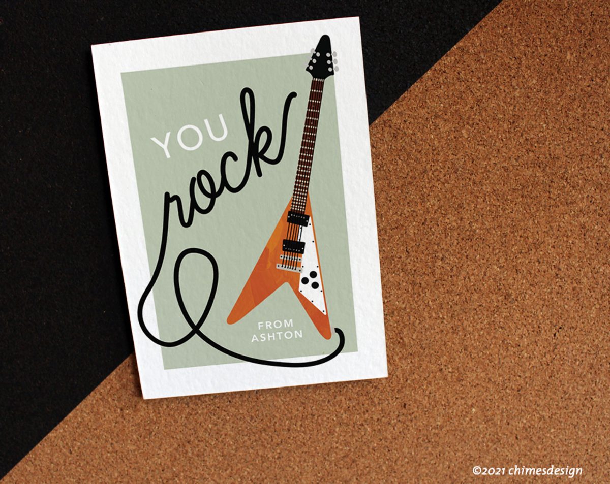 A greeting card with a guitar illustration that says "you rock" on a cork background